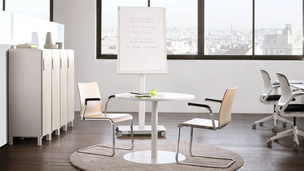 workspace with a low touchdown table and two chairs in front of a white board