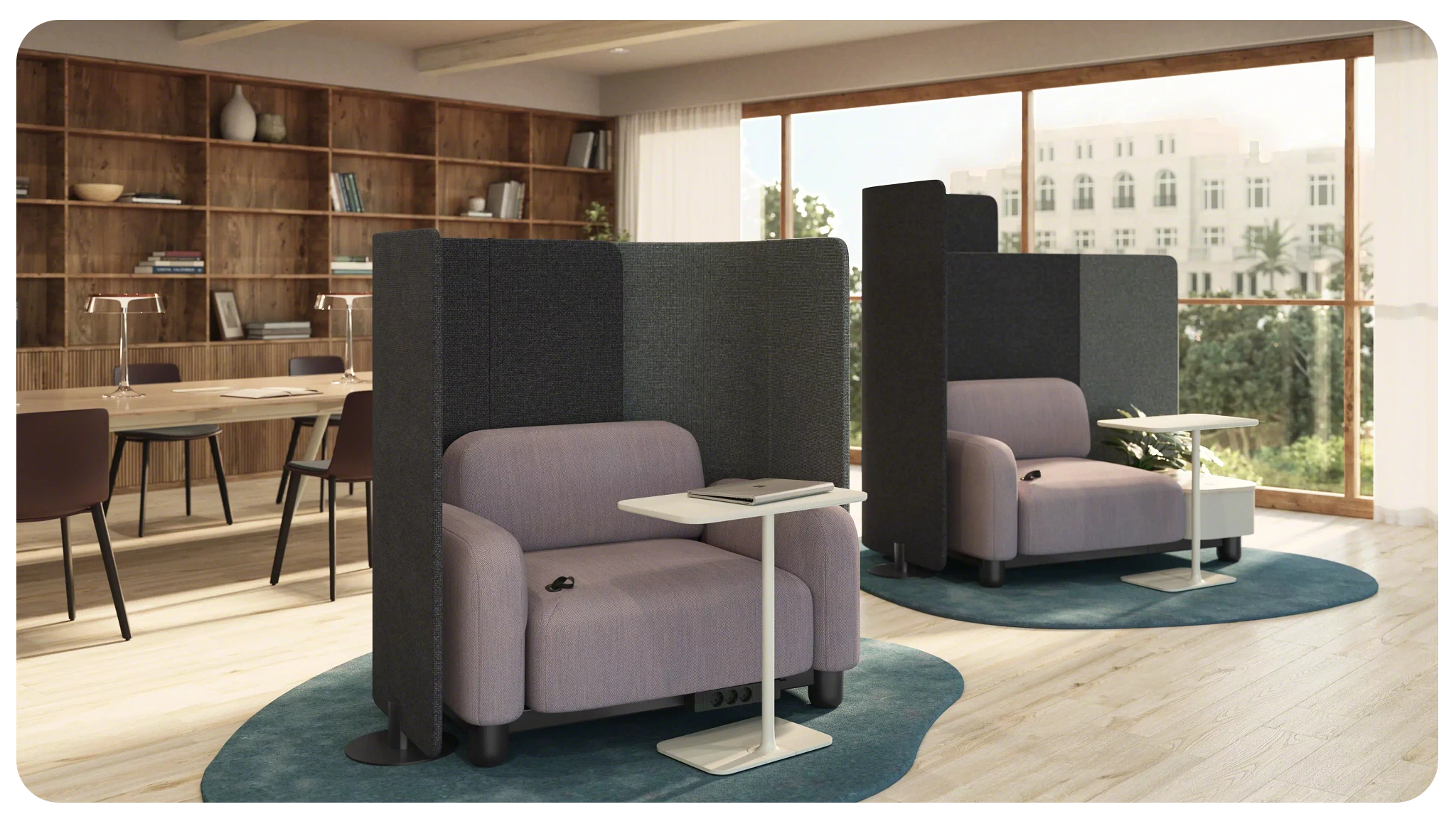 focus area in a library room with a large table in the back surrounded by chairs and two focus nooks allowing for more privacy