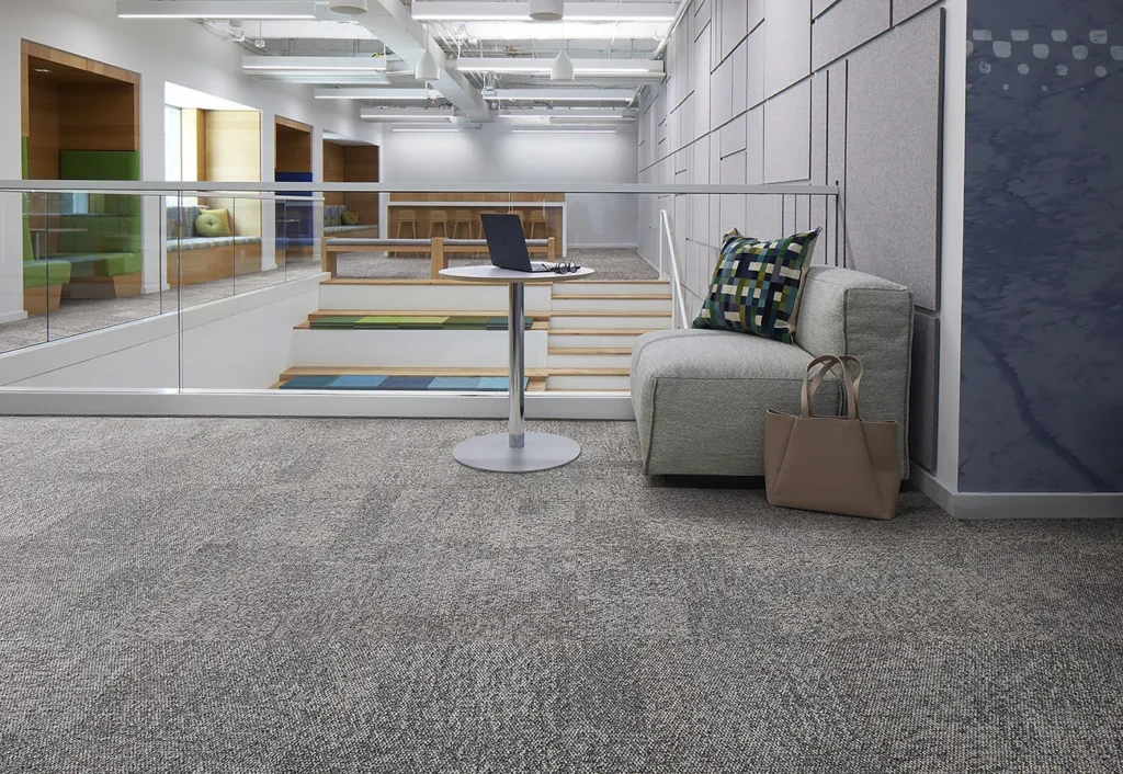 open plan area with carpet flooring and different seating options for work or socializing